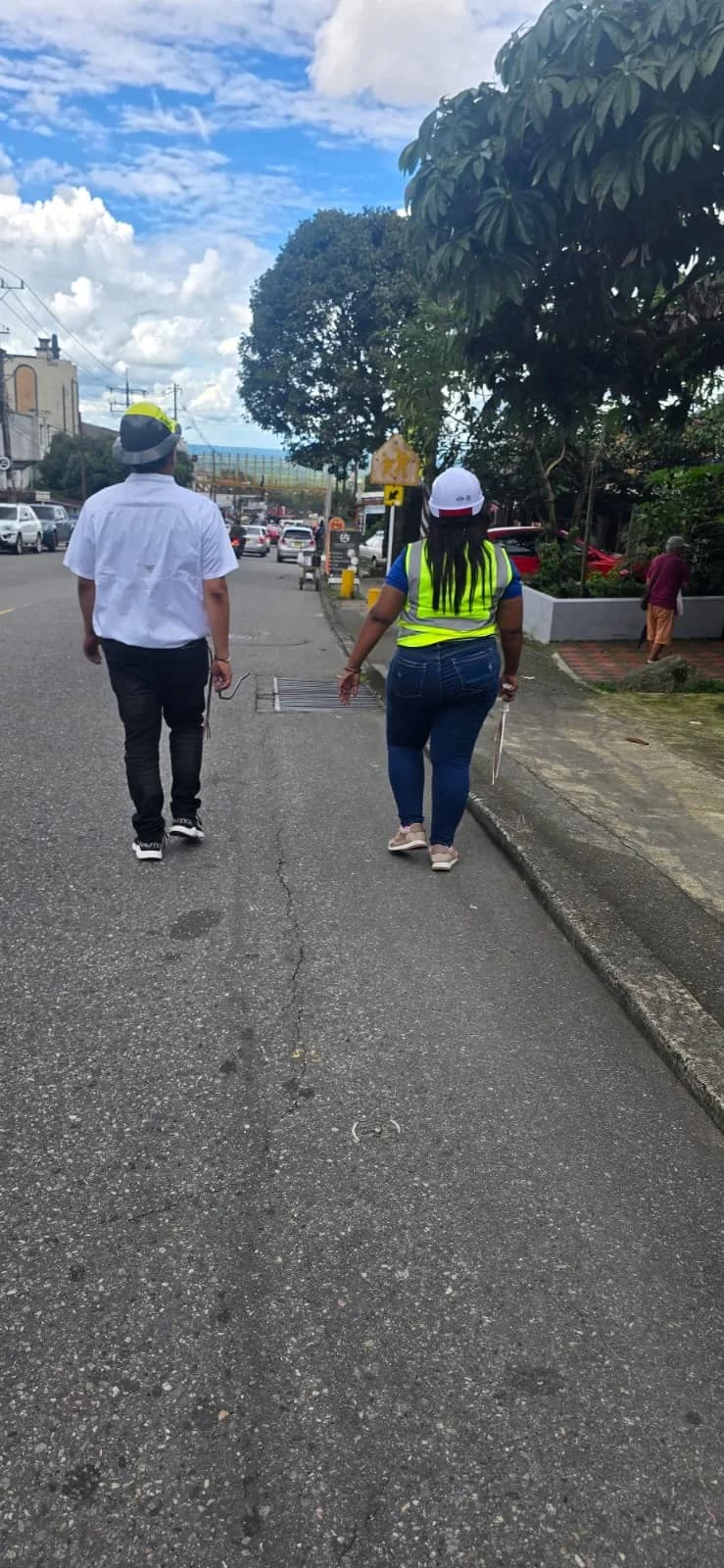 Supervisor y señalera de la cuadrilla, con casco y chaleco reflectivo, recorriendo la vía intervenida en un día despejado.