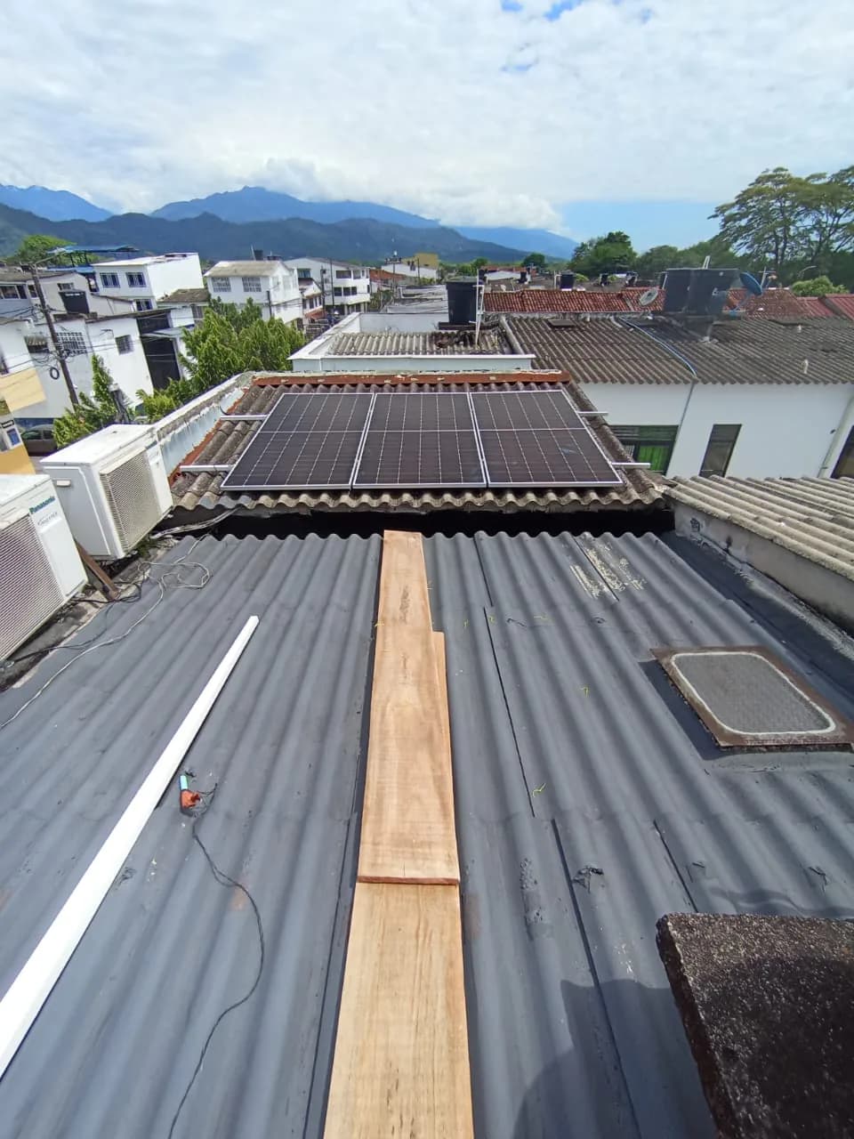 Primeros módulos montados sobre la teja de barro del segundo piso, con los rieles ya fijados y la cordillera de fondo.