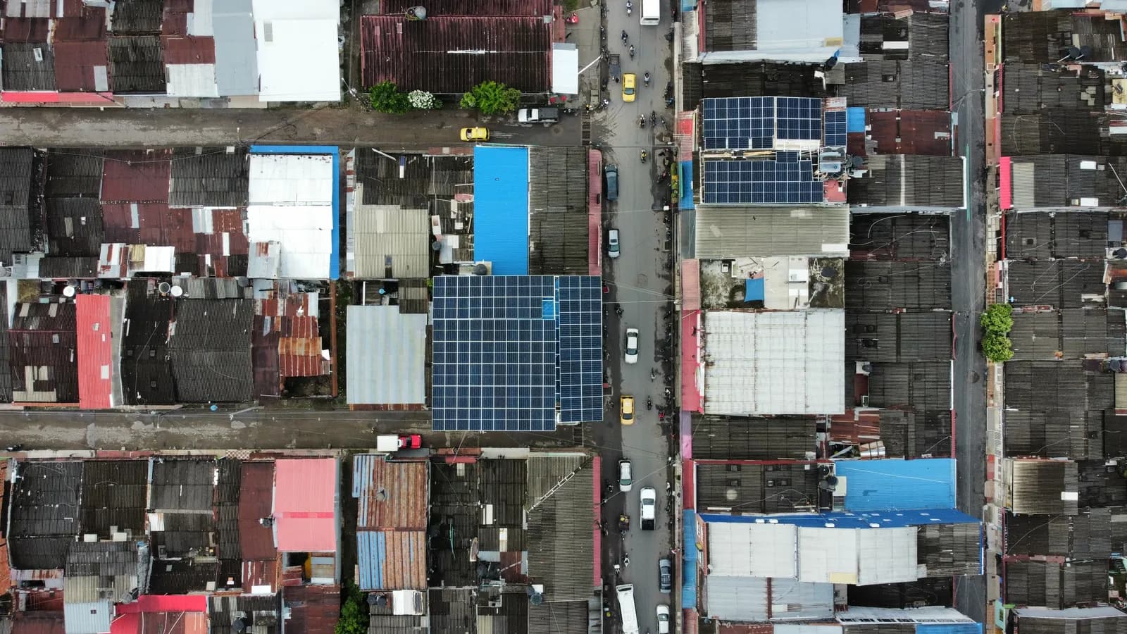 Vista cenital del damero urbano con las cubiertas solares del cliente destacando entre decenas de techos de zinc del centro del pueblo.
