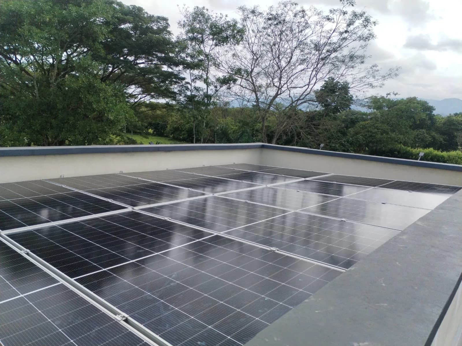 Arreglo de módulos instalado de forma coplanar sobre la azotea de la vivienda, con el paisaje de piedemonte al fondo.