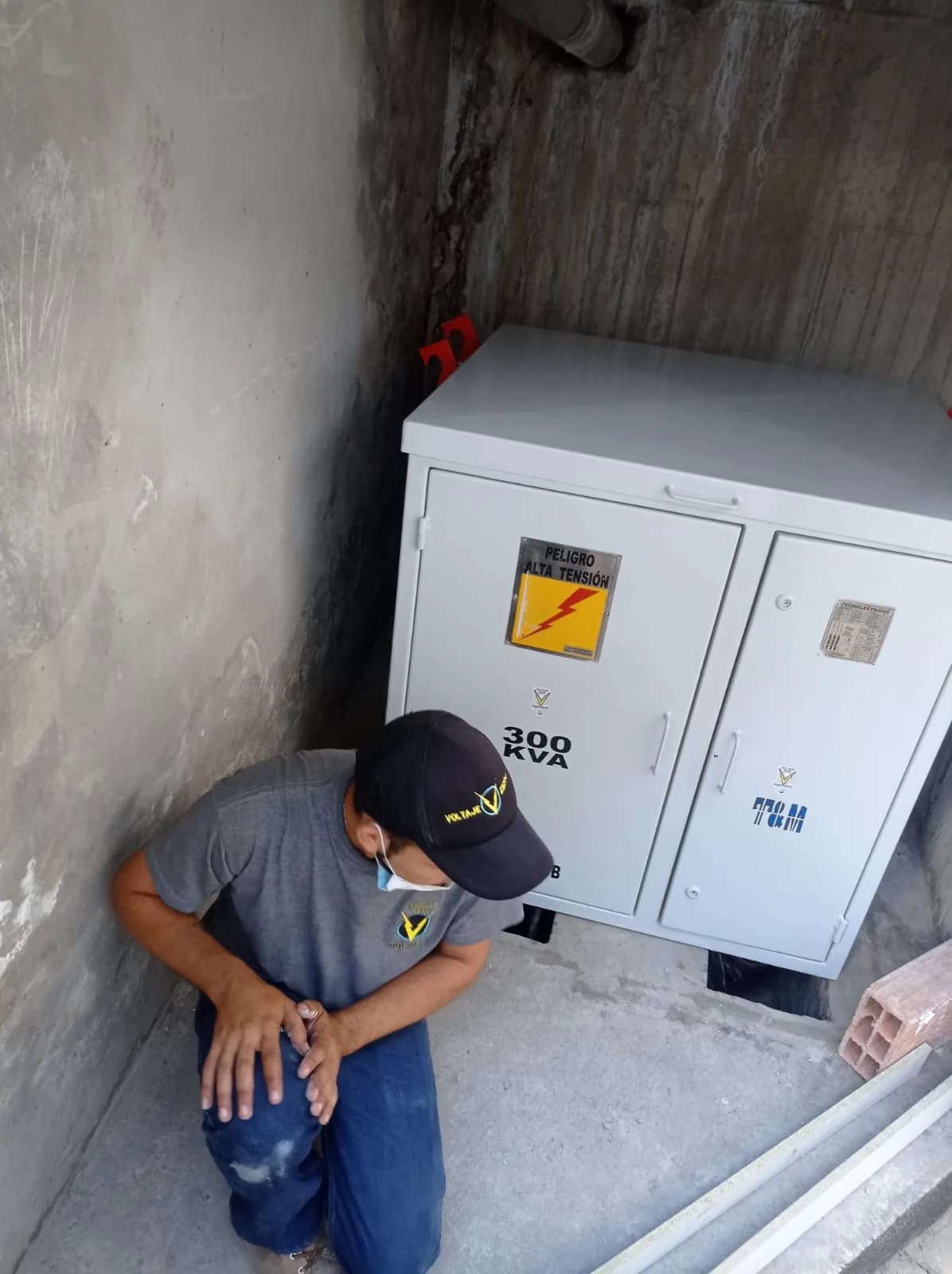 Técnico con uniforme de Voltaje Zero junto al transformador de 300 kVA ya ubicado en el cárcamo.